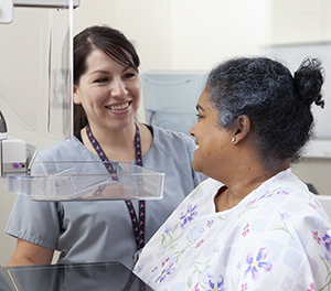 Technician helping woman during mammogram