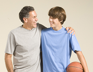 Man and teenage boy with basketball.