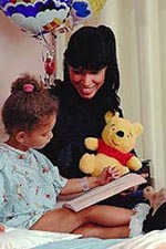 Picture of a young girl, in a hospital bed, with her mother