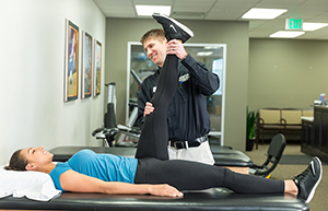 Physical therapist working with woman on leg stretches.