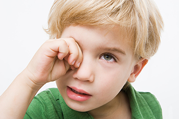 Boy rubbing his eyes